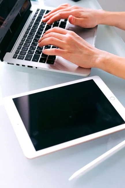 Un espace de travail moderne avec deux écrans d’ordinateur affichant des projets de conception web, mettant en avant la technologie et la productivité.